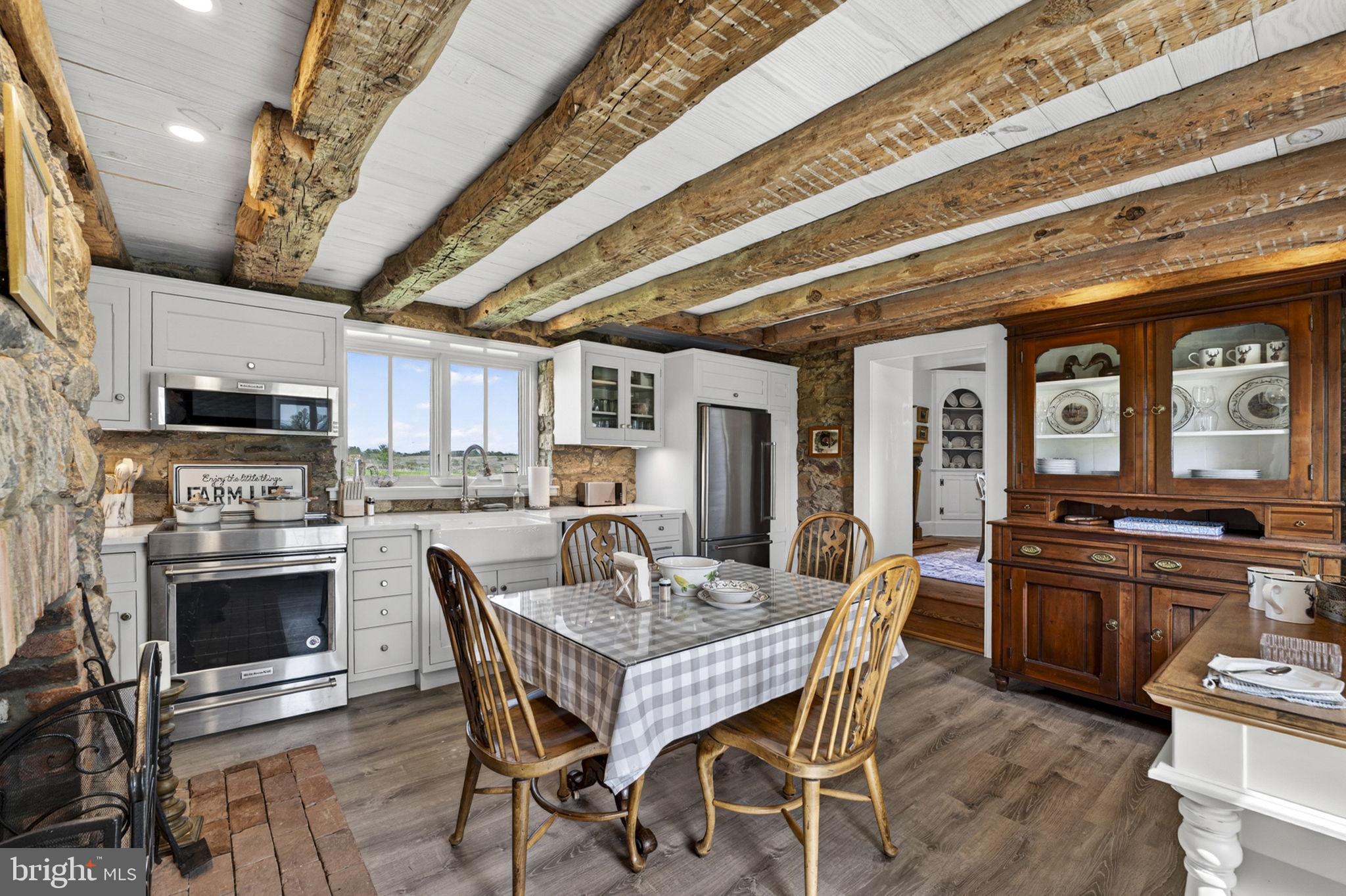 9078 Maidstone Road Delaplane, VA 20144 - Photo 18 of 36 a dining table with stainless steel appliances a stove top oven a sink and chairs