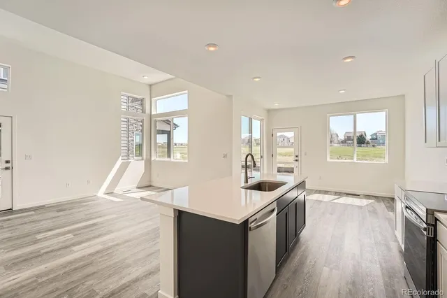 a kitchen with a sink and wooden floor