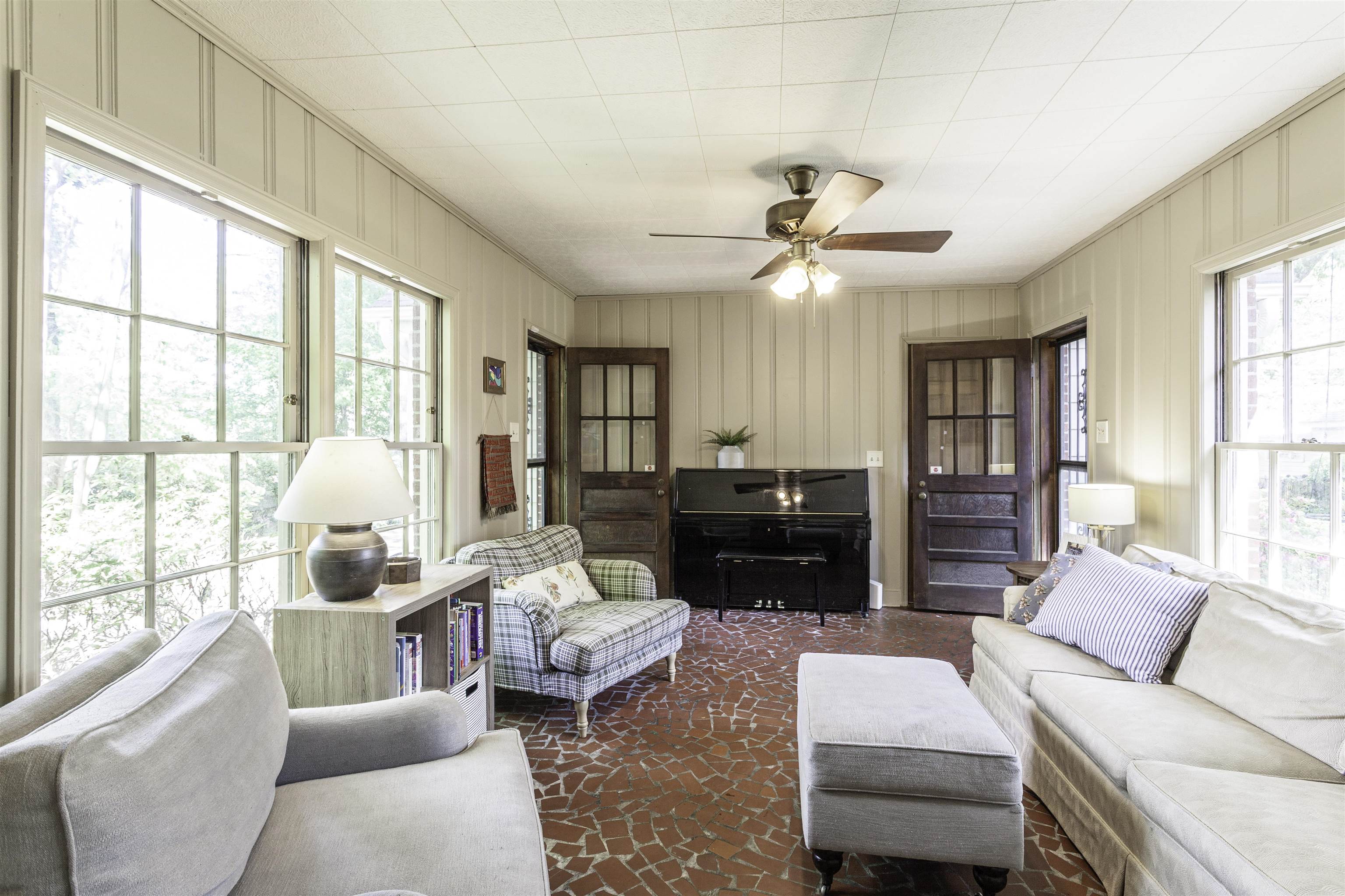 480 Colonial Road Memphis, TN 38117 - Photo 13 of 16 Spacious room featuring vertical paneling, red mosaic tile flooring, a ceiling fan, and multiple large windows