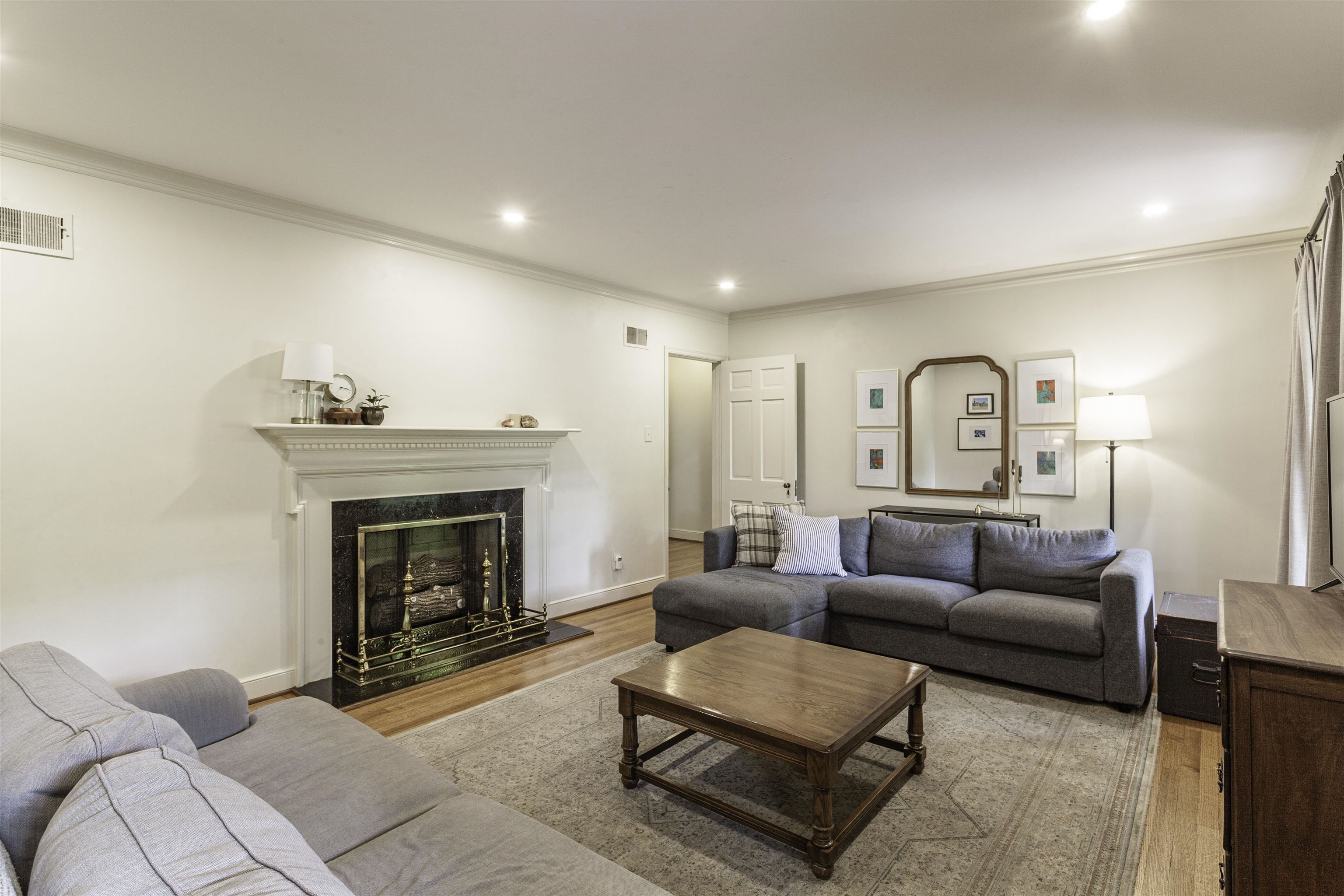 480 Colonial Road Memphis, TN 38117 - Photo 3 of 16 Living area featuring a classic white mantelpiece, dark stone fireplace surround, and a brass fireguard