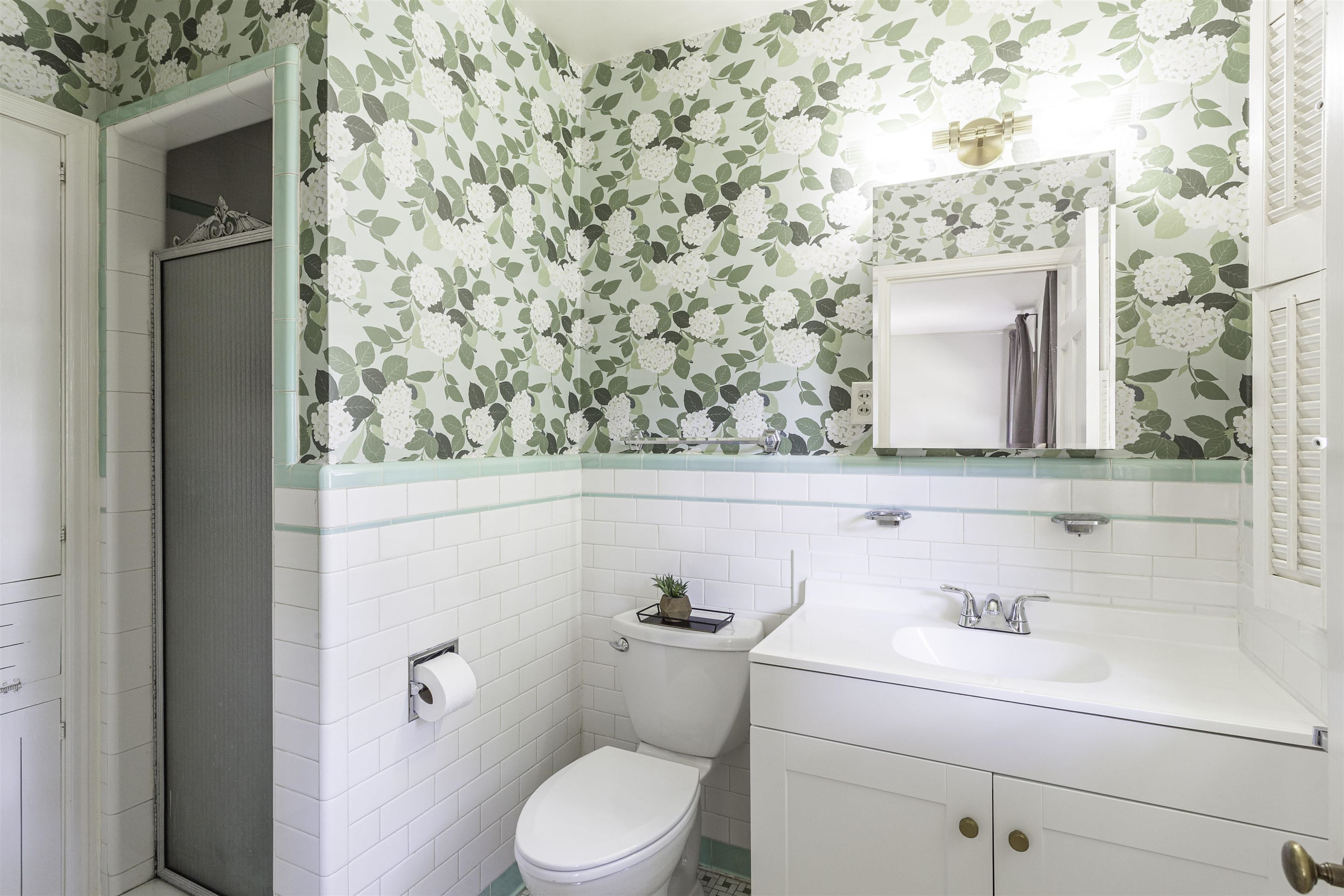 480 Colonial Road Memphis, TN 38117 - Photo 9 of 16 Bathroom featuring white subway tile wainscoting, floral wallpaper, and a vanity with an integrated sink
