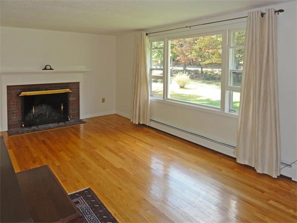 225 Stow Road Harvard, MA 01451 - Photo 4 of 24 a view of empty room with wooden floor and fireplace