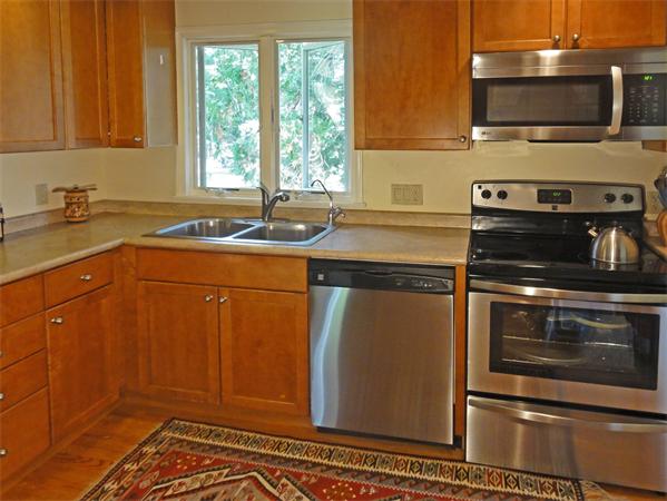 225 Stow Road Harvard, MA 01451 - Photo 6 of 24 a kitchen with stainless steel appliances granite countertop a sink stove and microwave
