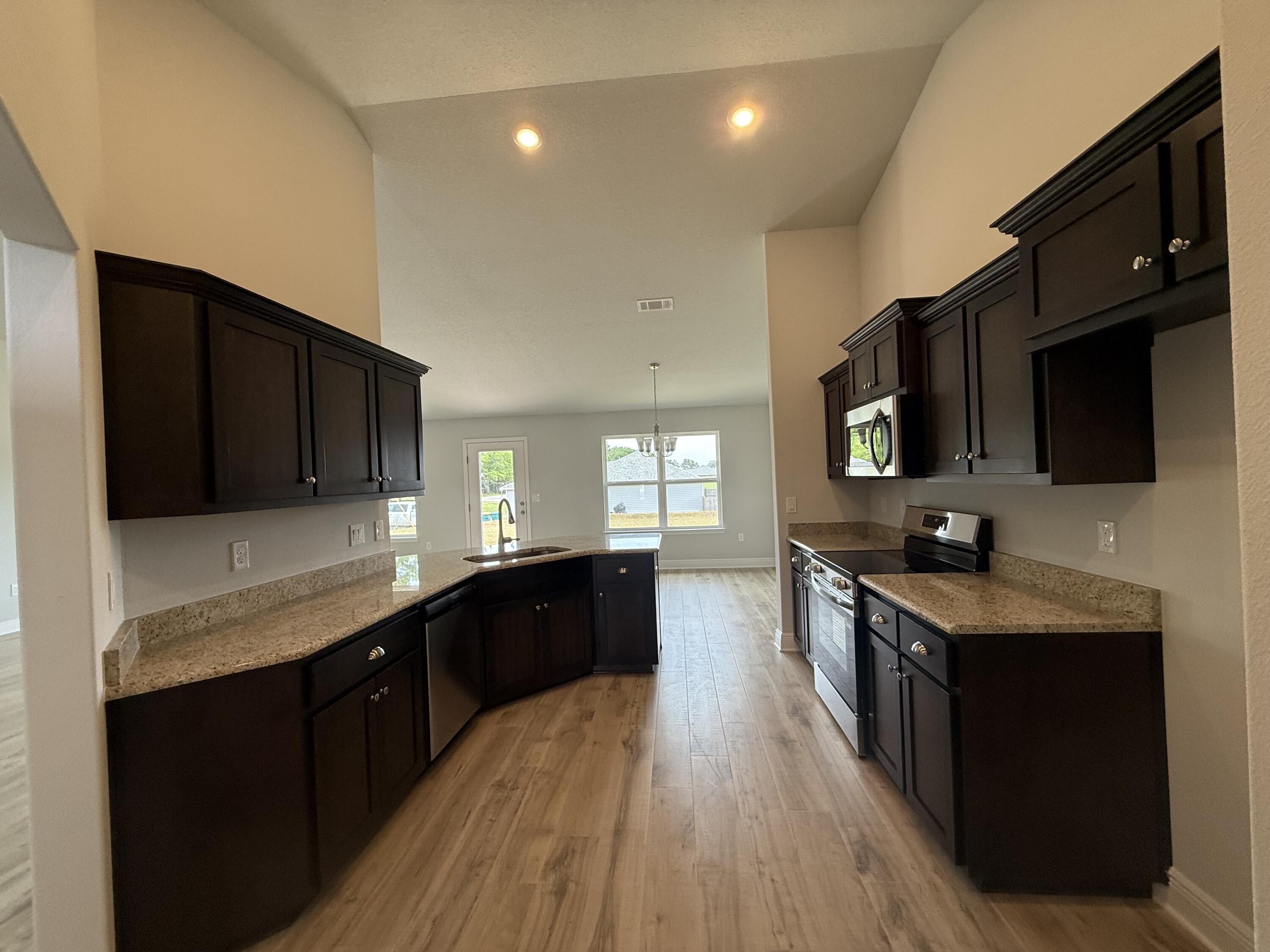 6000 Crocket Cove Crestview, FL 32539 - Photo 4 of 20 a kitchen with stainless steel appliances a sink stove and microwave