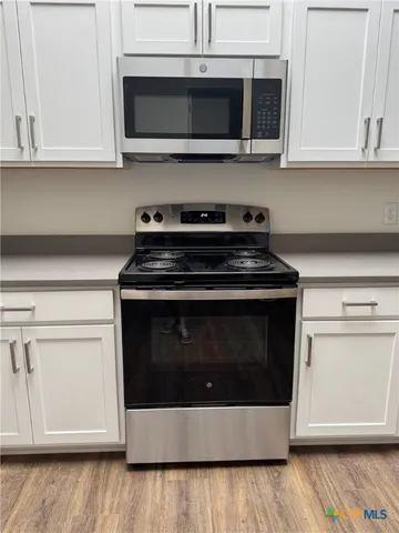 a view of an empty kitchen and cabinets