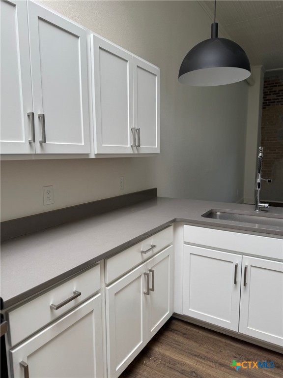 11 South Main Street, Unit 106 Temple, TX 76501 - Photo 5 of 13 a kitchen with granite countertop white cabinets and a sink