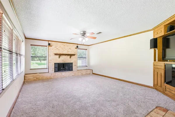 an empty room with windows and fireplace