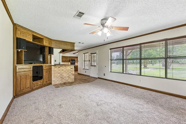 a view of an empty room with a kitchen