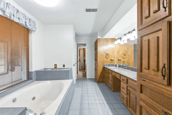 a large bathroom with a tub a double vanity sink and mirror