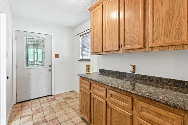 a kitchen with granite countertop cabinets and window