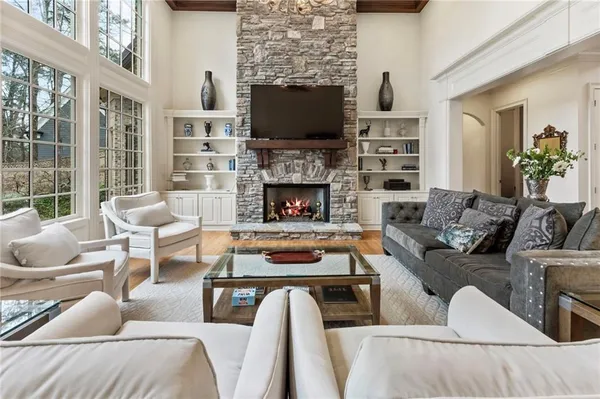 a living room with furniture a flat screen tv and a fireplace