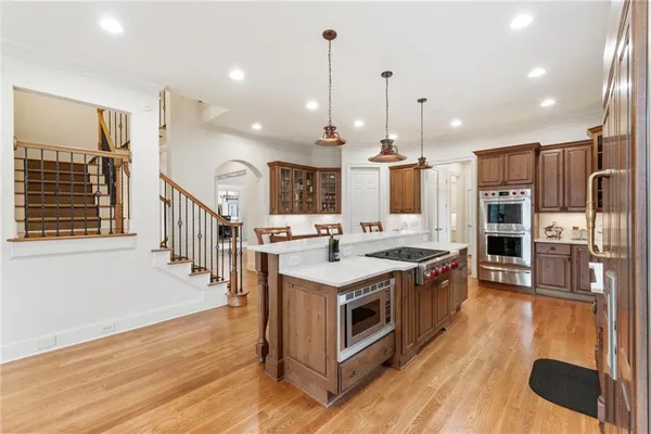 a kitchen with kitchen island granite countertop a sink appliances and cabinets