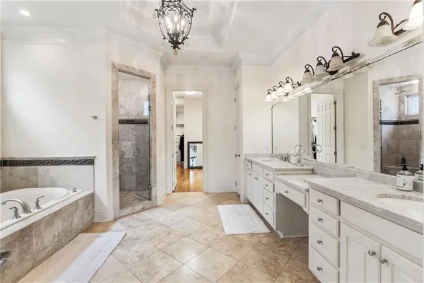a spacious bathroom with a double vanity sink large mirror and a bathtub