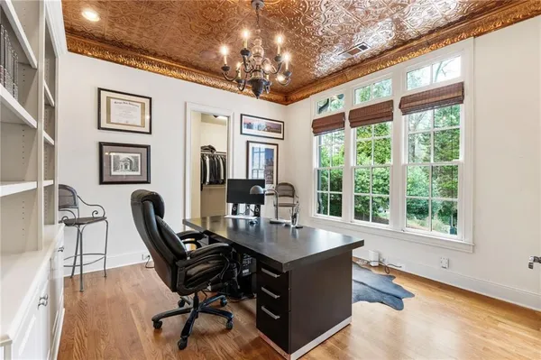 a dining room with furniture a chandelier and wooden floor