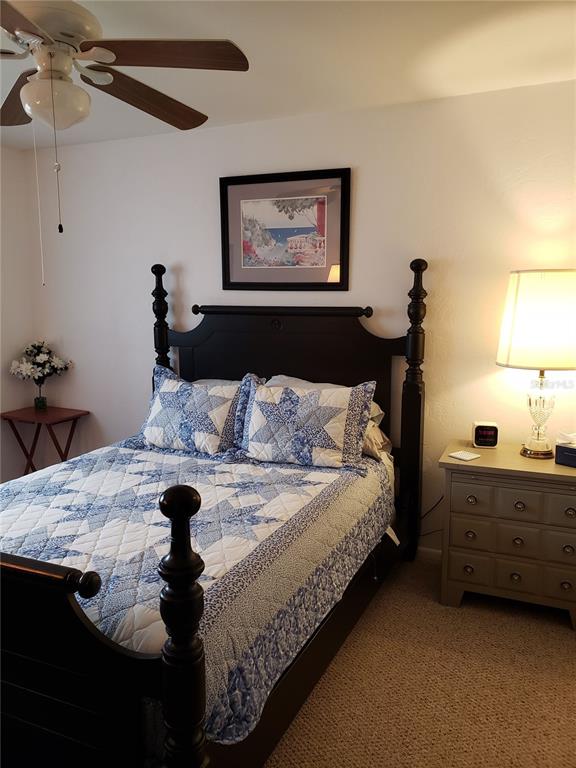 25225 Rampart Boulevard, Unit 1908 Punta Gorda, FL 33983 - Photo 8 of 15 a bed sitting in a bedroom next to a window and a lamp