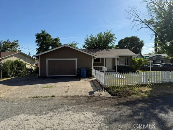 a front view of a house with a yard and potted plants