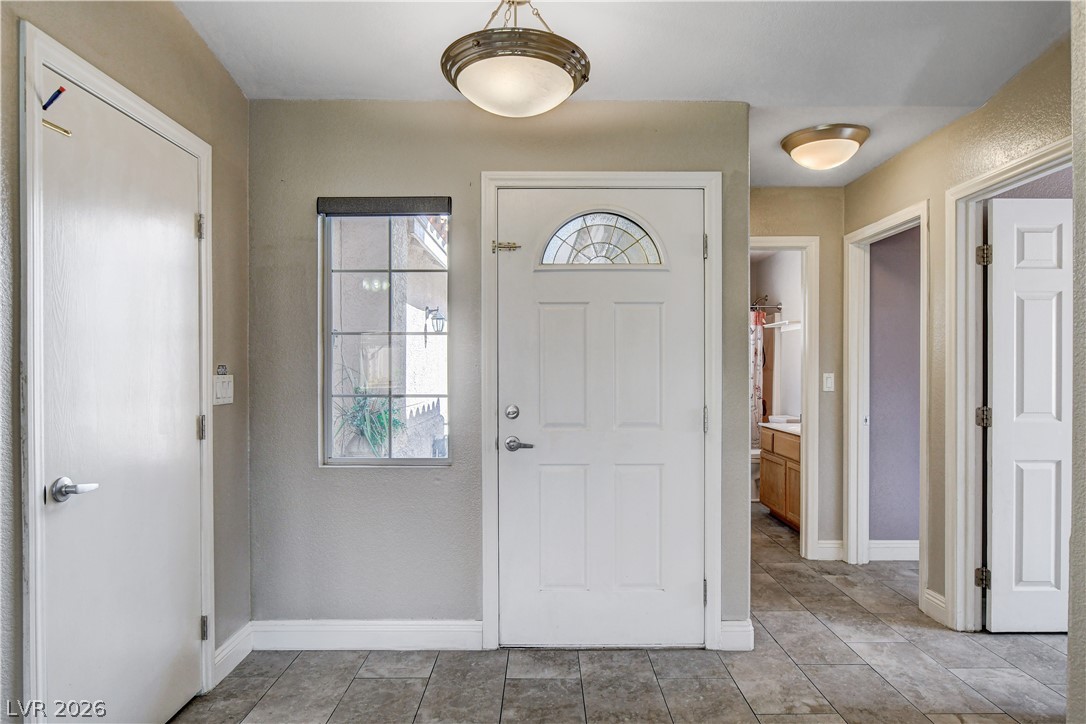 910 Cobblestone Cove Road North Las Vegas, NV 89081 - Photo 3 of 30 A welcoming entry features practical tile flooring and an inviting arched glass front door.
