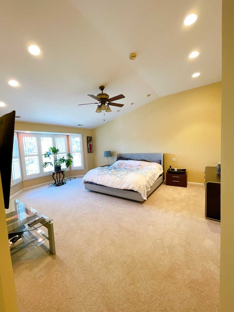 2047 Sheridan Road Buffalo Grove, IL 60089 - Photo 13 of 25 a bedroom with a bed a couch and a flat screen tv