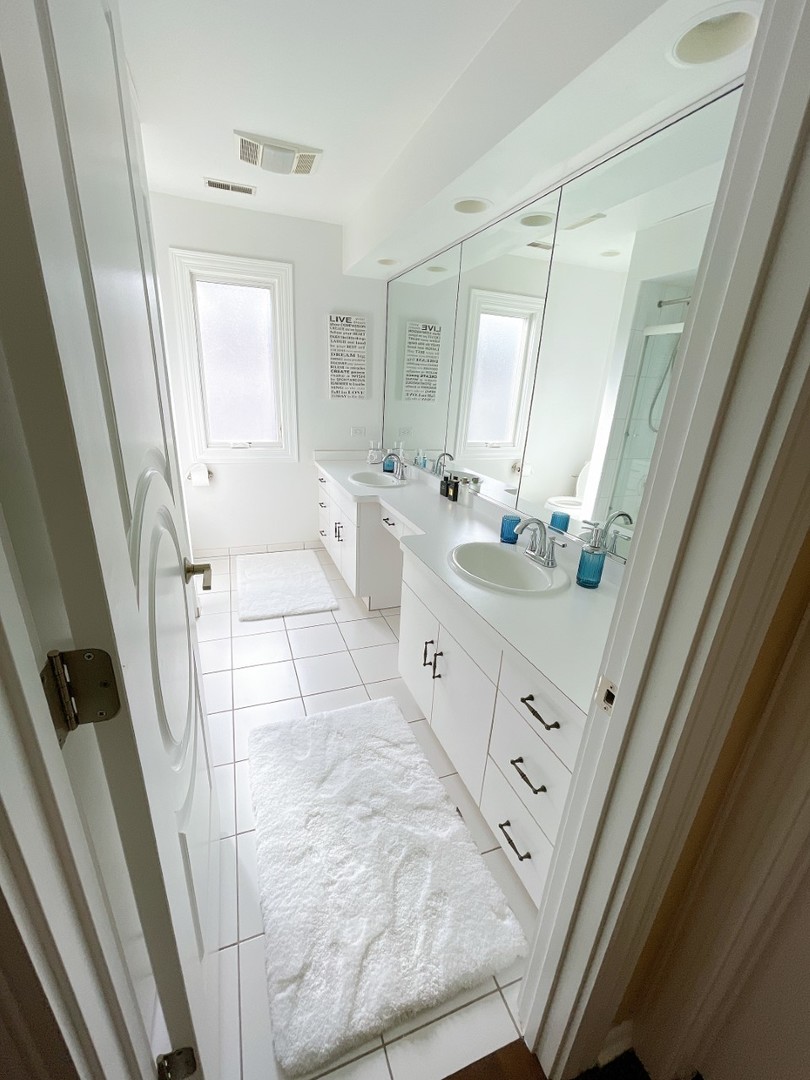 2047 Sheridan Road Buffalo Grove, IL 60089 - Photo 19 of 25 a spacious bathroom with a double vanity sink a mirror and a shower