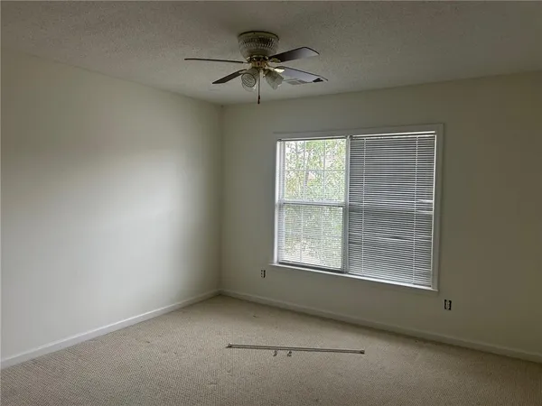 an empty room with a window and a ceiling fan