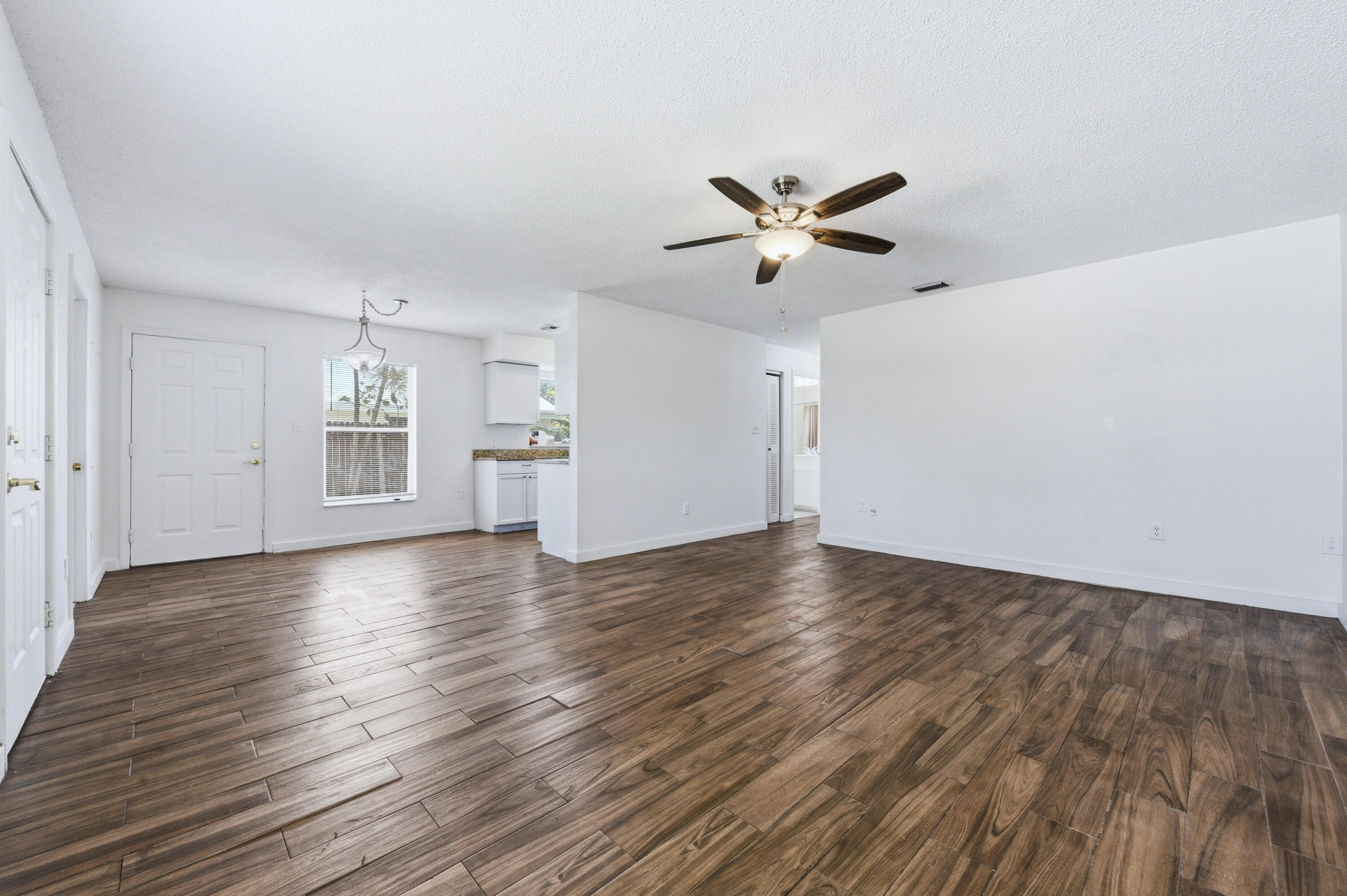 6088 Heather Street Jupiter, FL 33458 - Photo 5 of 18 a view of empty room with wooden floor and ceiling fan