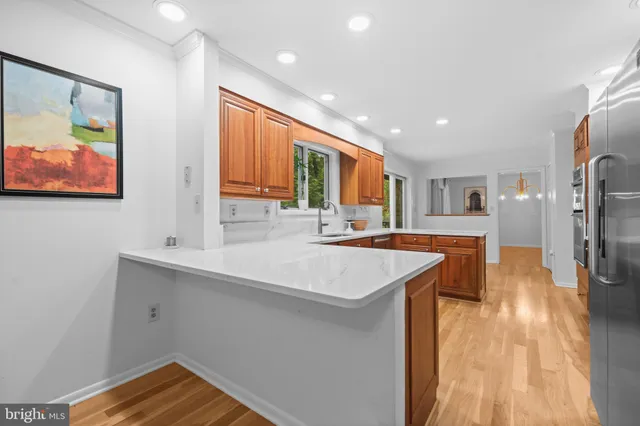 a kitchen with stainless steel appliances granite countertop a refrigerator a stove and a sink