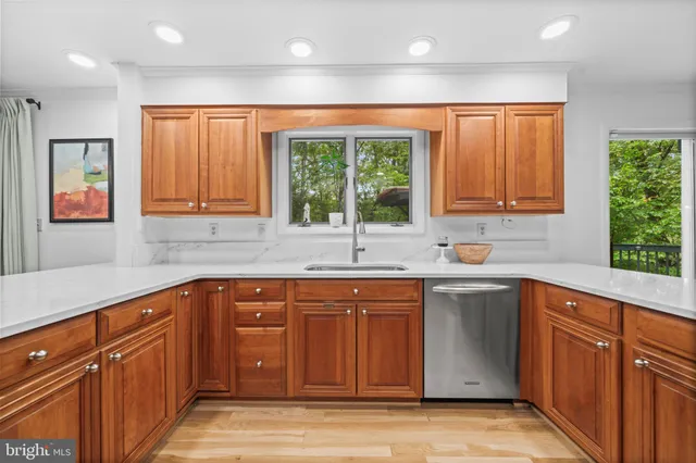 a kitchen with stainless steel appliances granite countertop a stove a refrigerator and a sink with wooden cabinets