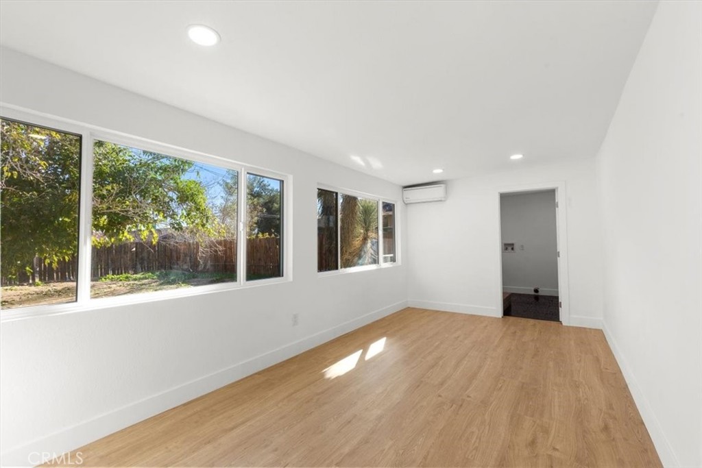 6431 Goleta Avenue Yucca Valley, CA 92284 - Photo 11 of 23 a view of an empty room with wooden floor and a window
