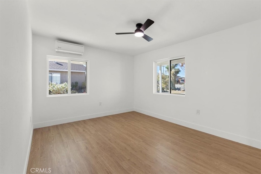 6431 Goleta Avenue Yucca Valley, CA 92284 - Photo 13 of 23 a view of empty room with wooden floor and fan