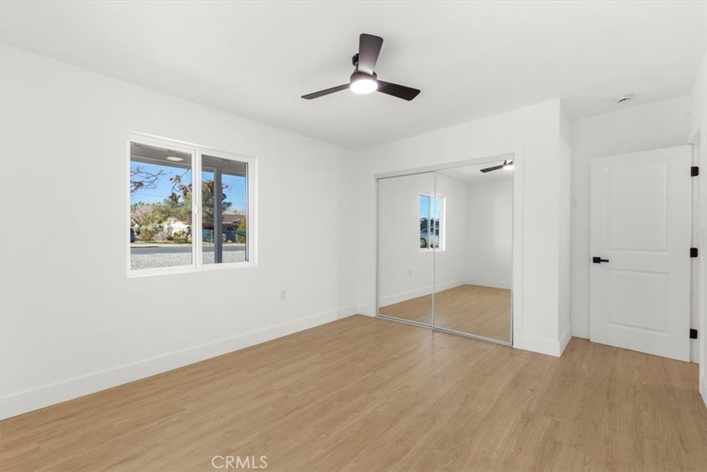 6431 Goleta Avenue Yucca Valley, CA 92284 - Photo 15 of 23 a view of an empty room with wooden floor and a ceiling fan