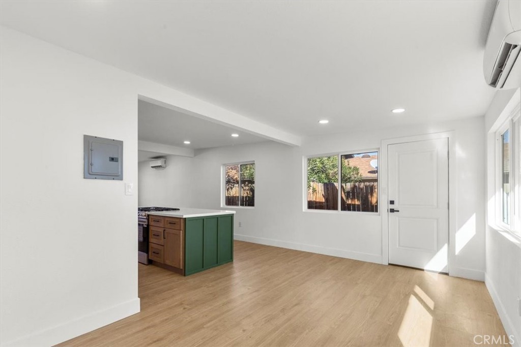 6431 Goleta Avenue Yucca Valley, CA 92284 - Photo 10 of 23 an empty room with kitchen and wooden floor