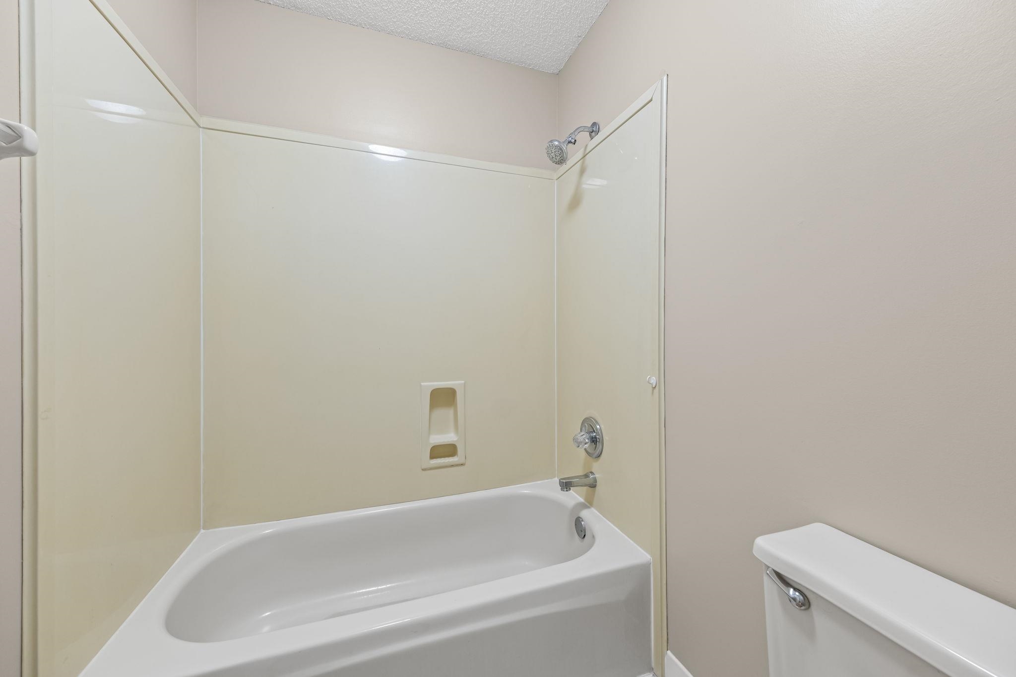 8409 Ridge Fall Cove Memphis, TN 38018 - Photo 23 of 28 Bathroom featuring a textured ceiling and shower / washtub combination