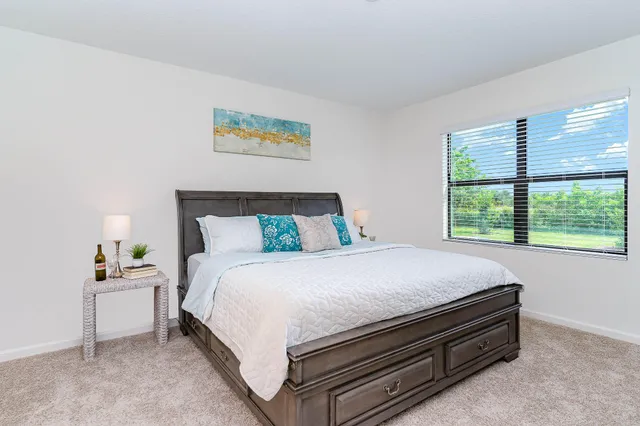 a bed sitting in a bedroom next to a window