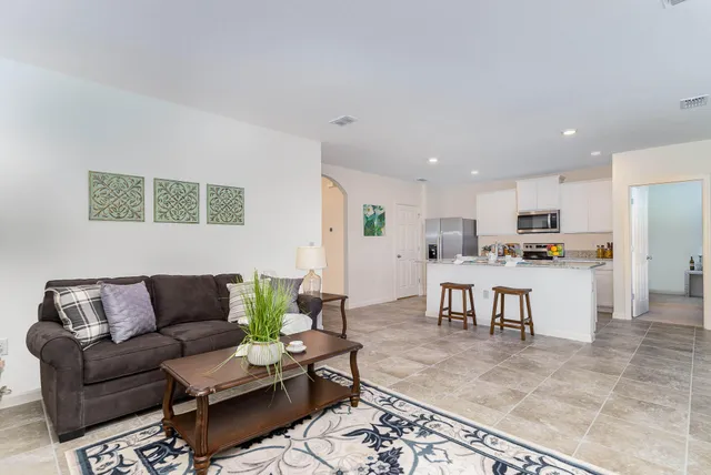 a living room with furniture kitchen view and a dining table