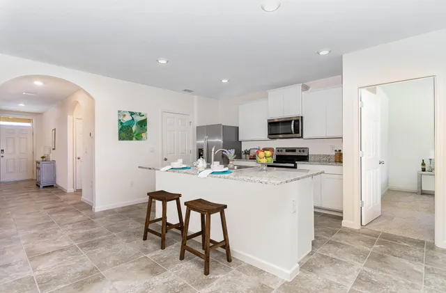 a kitchen with a sink and chairs