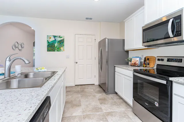 a kitchen with stainless steel appliances granite countertop a refrigerator stove and sink