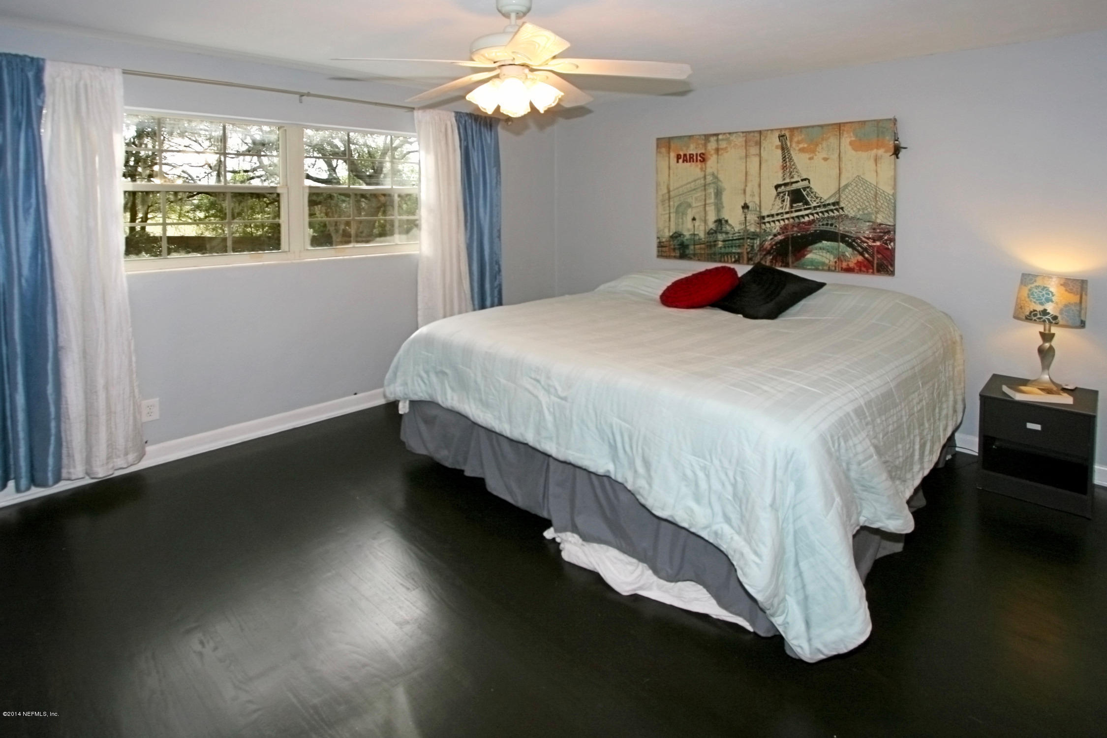 6404 Heidi Road Jacksonville, FL 32277 - Photo 15 of 26 a bedroom with a bed and a chandelier