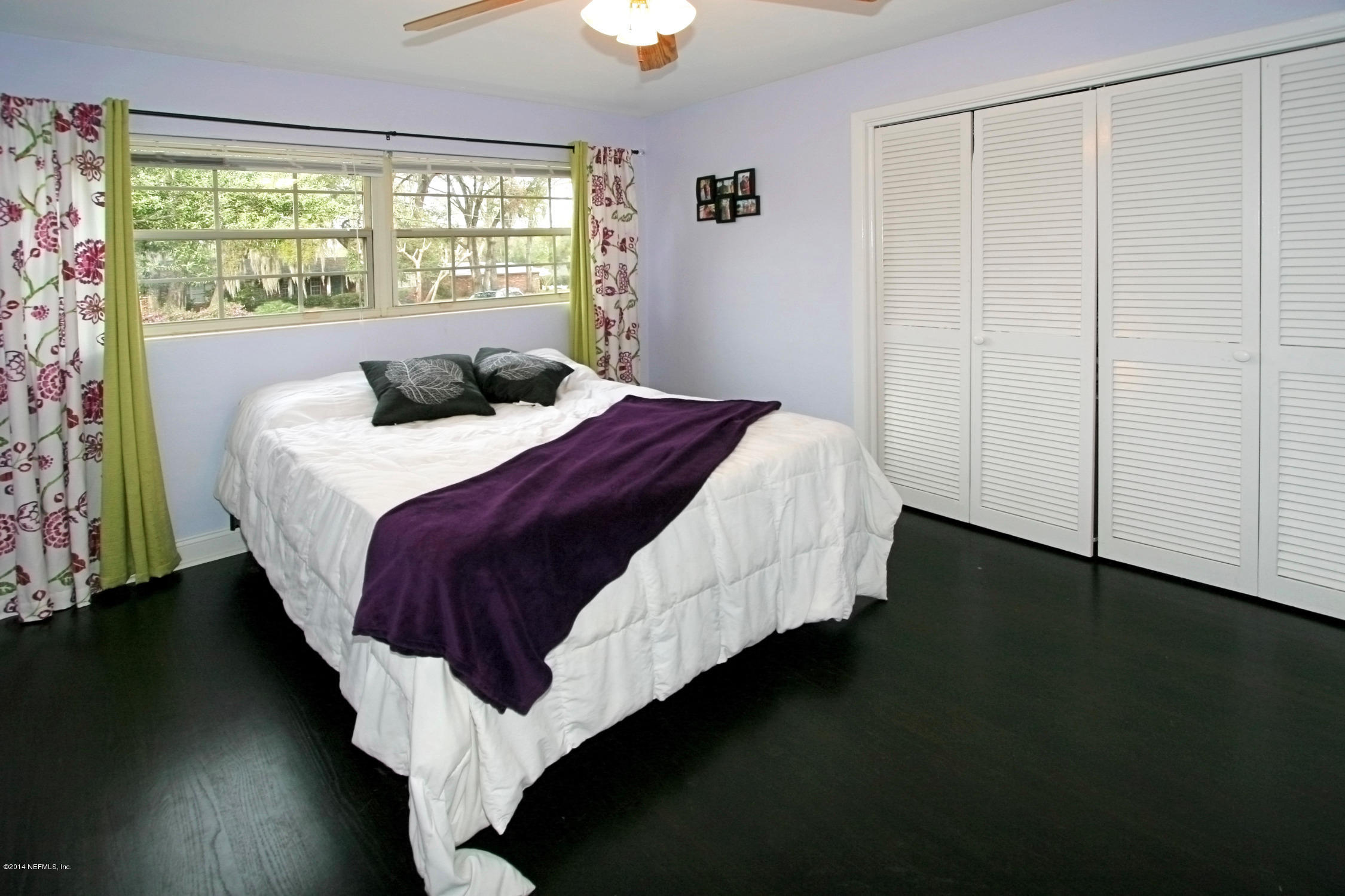 6404 Heidi Road Jacksonville, FL 32277 - Photo 21 of 26 a bed sitting in a bedroom next to a window