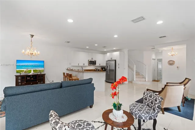 a living room with furniture kitchen and a chandelier