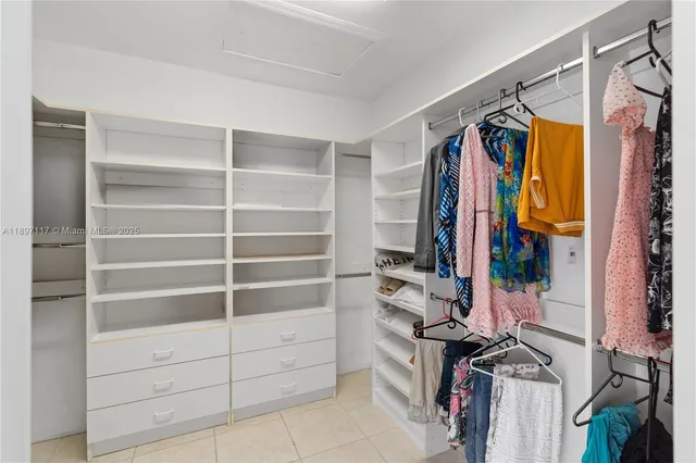 a view of walk in closet with clothes and shoes