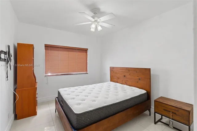 a bedroom with a bed and a lamp with the dresser