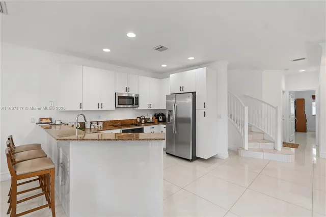a kitchen with refrigerator and cabinets