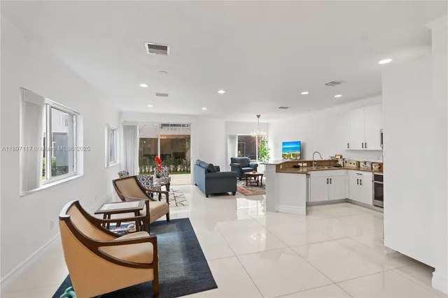 a living room with furniture a flat screen tv and a window