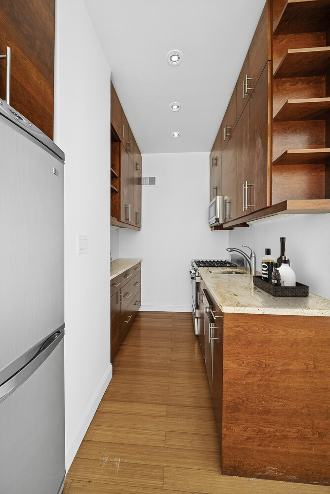159 Madison Avenue, Unit 9B Manhattan, NY 10016 - Photo 10 of 16 a kitchen with granite countertop a stove and a refrigerator