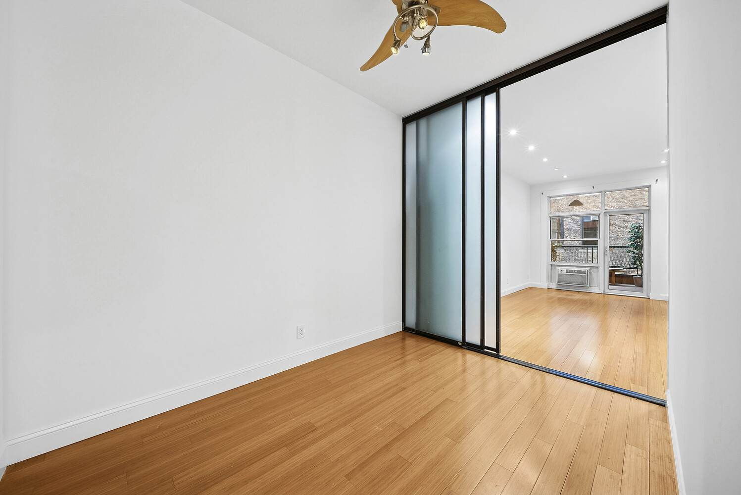 159 Madison Avenue, Unit 9B Manhattan, NY 10016 - Photo 6 of 16 an empty room with wooden floor and windows