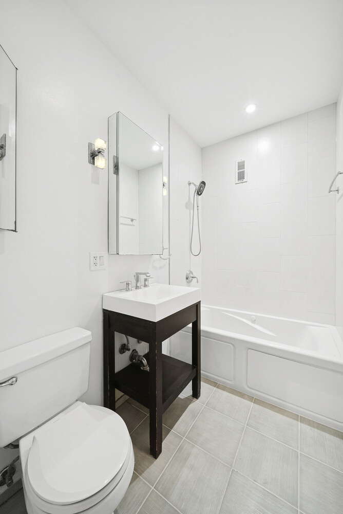 159 Madison Avenue, Unit 9B Manhattan, NY 10016 - Photo 9 of 16 a bathroom with a sink a toilet and shower