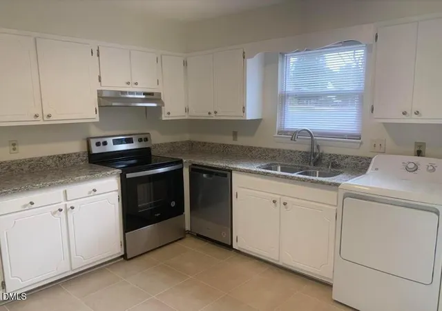 a kitchen with granite countertop white cabinets and white stainless steel appliances