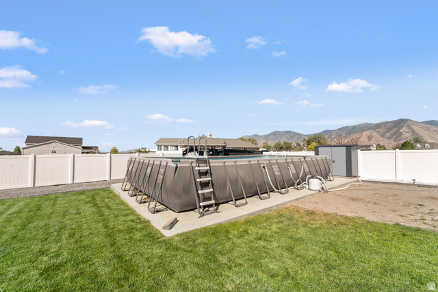 3678 Spiral Springs Road, Unit 204 Tooele, UT 84074 - Photo 44 of 59 Expansive backyard featuring a manicured lawn, an above-ground pool, and white privacy fencing