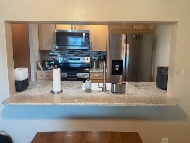 a kitchen with microwave a sink and cabinets