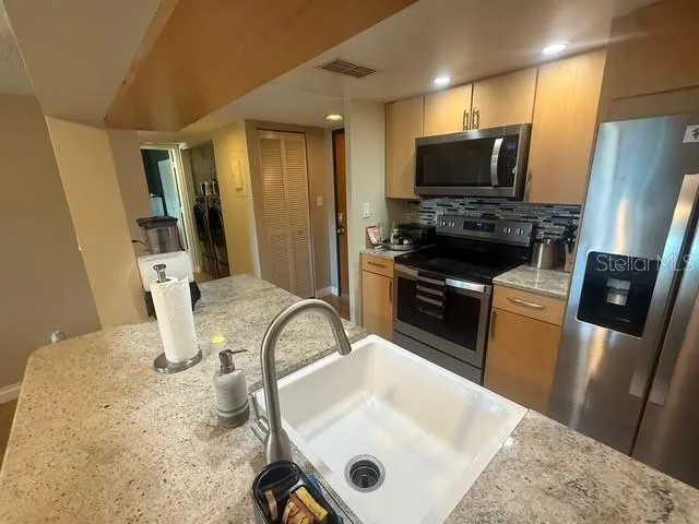 a kitchen with sink a microwave a stove and refrigerator